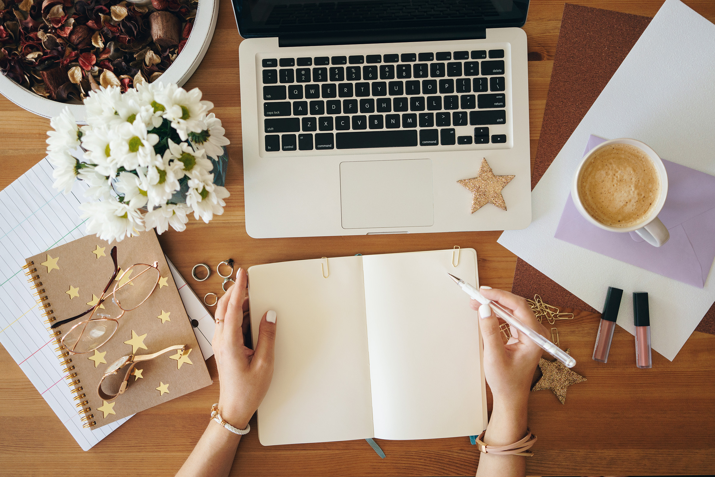 Young woman making notes and working on a laptop